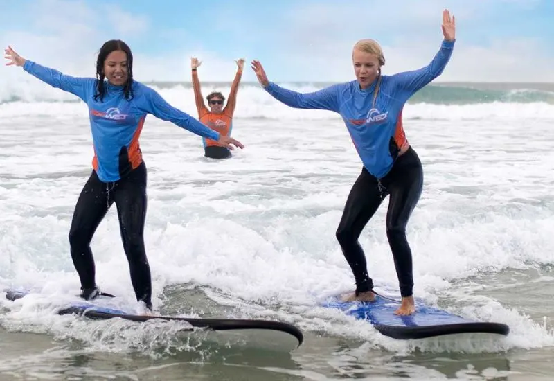 Surfing lessons near morjim resort for beginners at beach