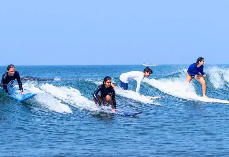 Surfing activity near resorts close to Morjim Beach