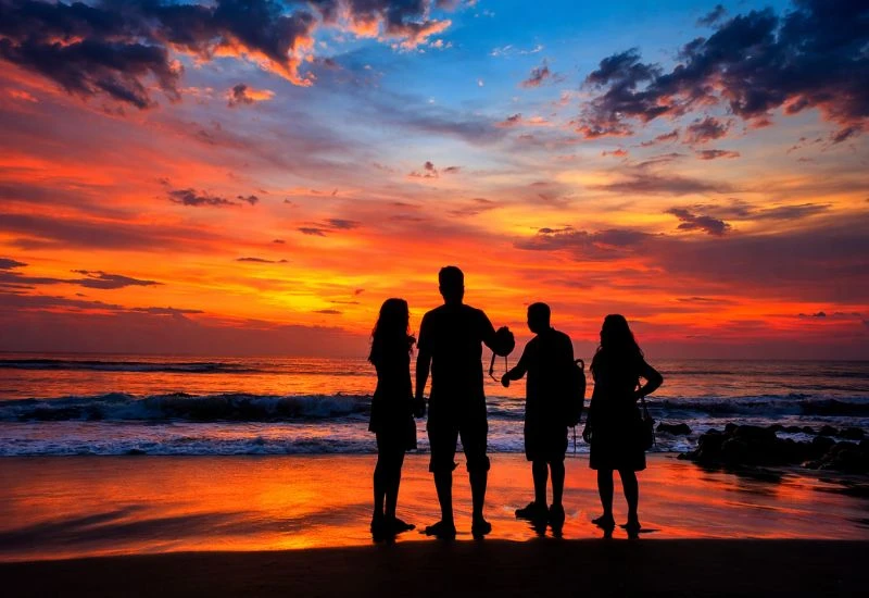 Silhouette group enjoying sunset near morjim beach goa resorts